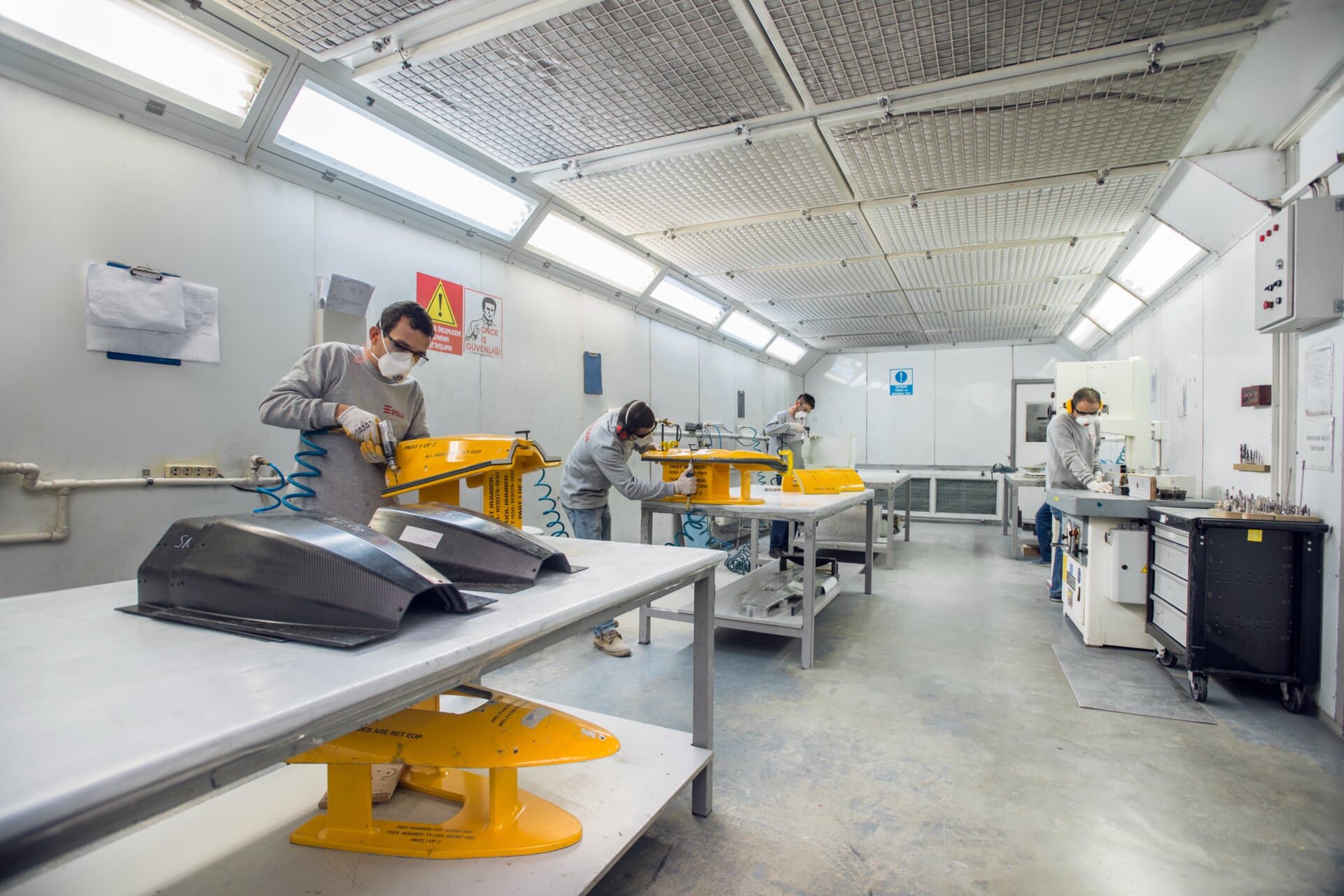 Factory assembly line with workers manufacturing composite parts